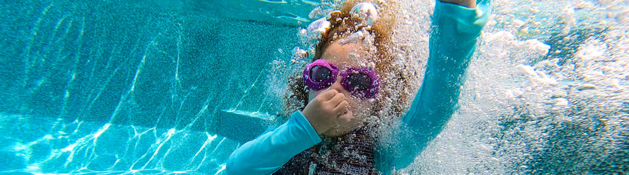 Warranty page header of girl underwater surrounded by bubbles
